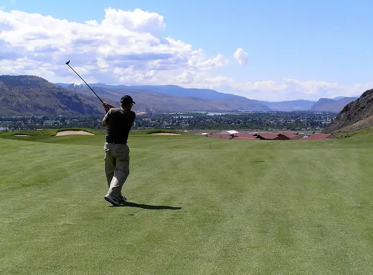 Jogador de golfe a executar um swing num campo verdejante